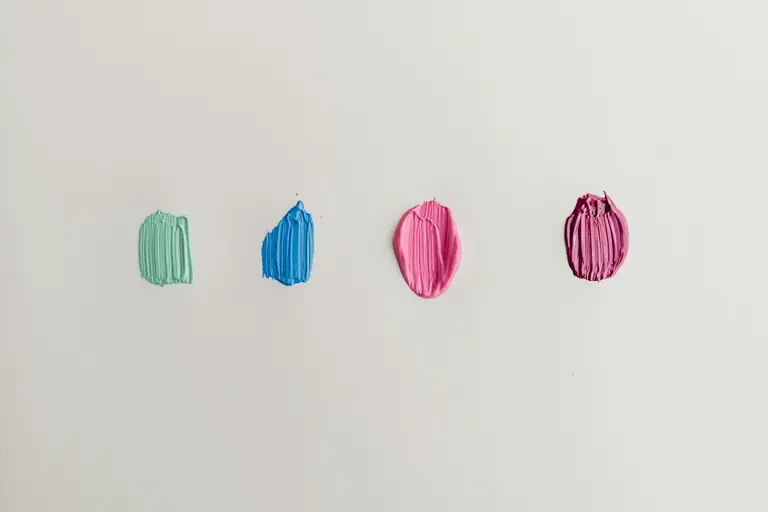 four green, blue, and pink paints