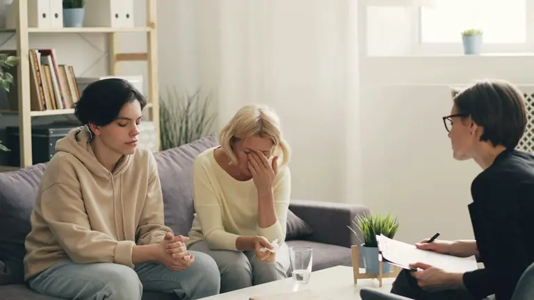 two women sitting on a couch talking to each other