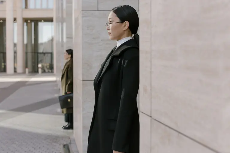 Profile of an elegant businesswoman in a modern urban environment.